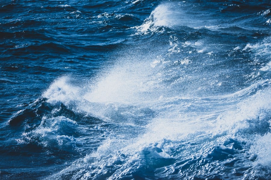 Employing a fast shutter speed to freeze spray created from a crashing wave impacting on the shore.