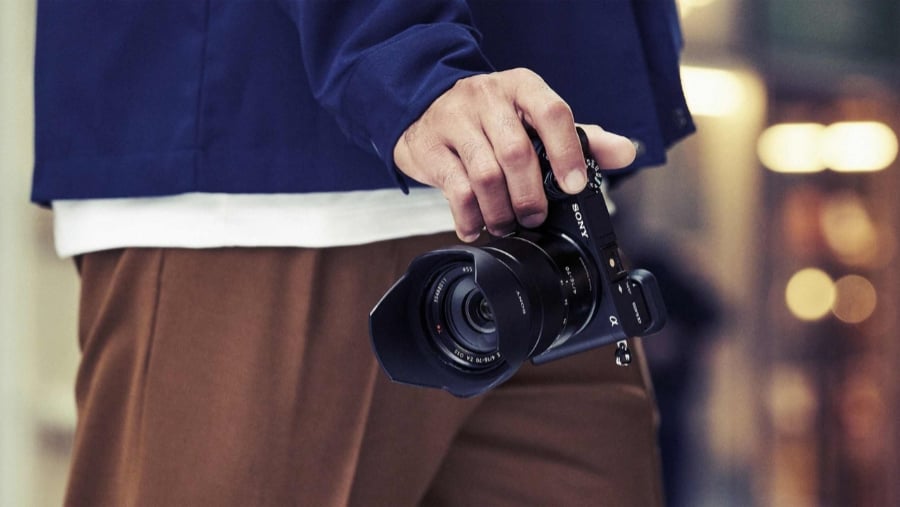  Photo Of man's hand holding Sony A6400 mirrorless camera<