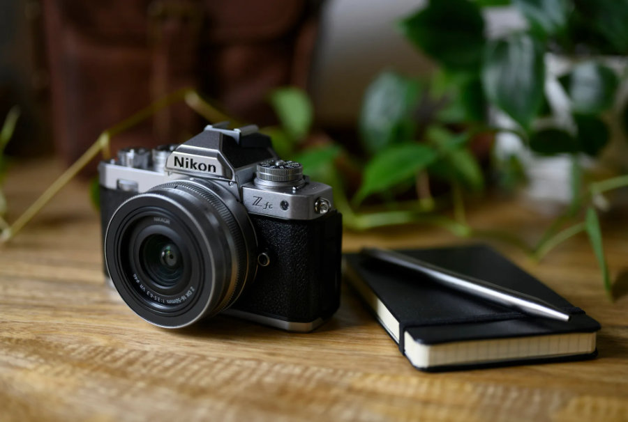  Photo of Nikon Z fc on desk with notebook, in silver<